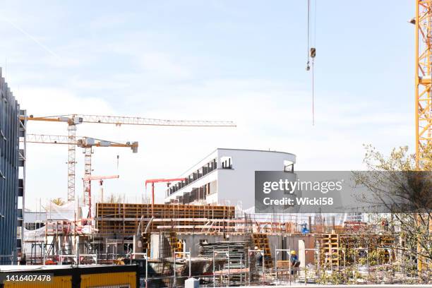 baustelle einer großen apartmentanlage und eines parkhauses - baustelle gerüst sonne stock-fotos und bilder