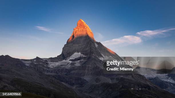 orange glowing matterhorn peak zermatt matterhorn sonnenaufgang schweiz - sunny stock-fotos und bilder