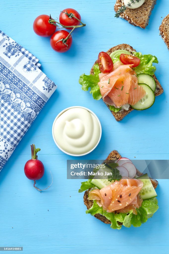 Sandwiches with smoked salmon, cucumber, lettuce, radish and mayo