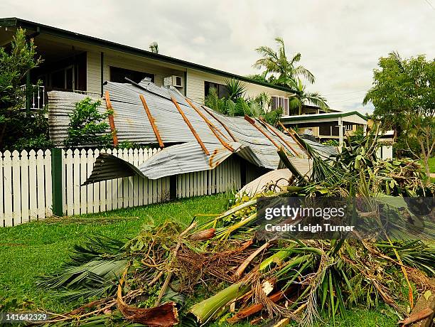 Section of a roof and vegetion debris is seen laying in the front yard of a house in the Townsvile suburb of Gulliver on March 21, 2012 in...