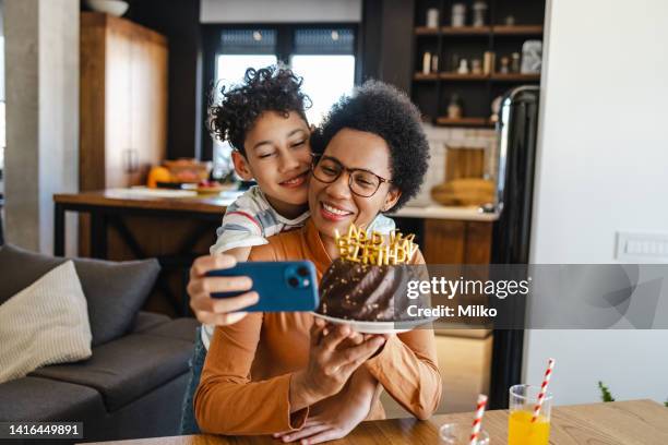 mother and son celebrating birthday at home an talking selfie - zoom birthday stock pictures, royalty-free photos & images