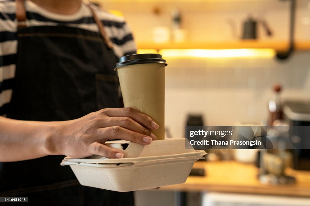 Crop person putting takeaway food out of paper bag