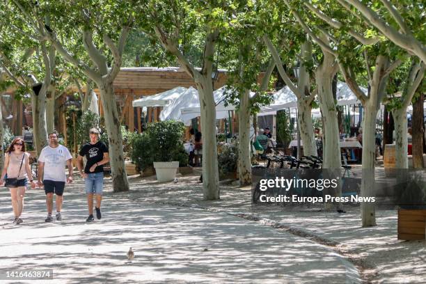 People walk around the Casa de Campo lake on August 21 in Madrid, Spain. Its 1535.52 hectares make this natural space the largest public park in...