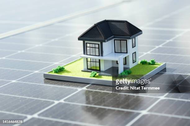 return on energy invested in rooftop solar panels for resident building. house, architecture model design of home ownership, on solar panels. housing development, clean energy, and green building concepts. - clean house stockfoto's en -beelden