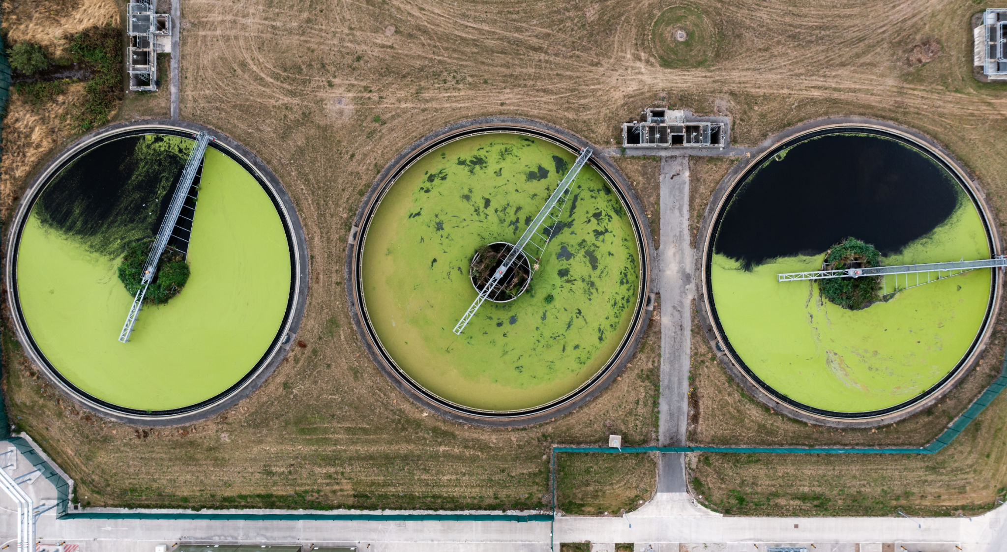 Aerial view above waste water treatment plant with green algae Aerial view above waste water treatment plant with green algae