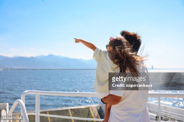 mädchen, das mit ihrem vater mit dem schiff reist und möwe sieht aus - daily life in istanbul stock-fotos und bilder