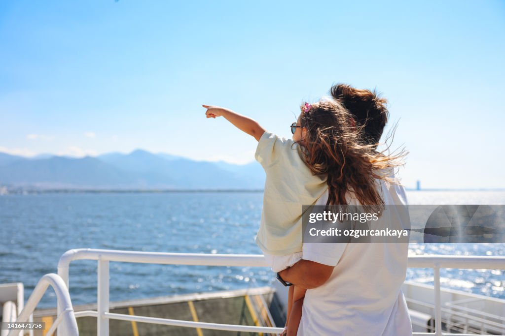 Girl traveling by ship with her father and looking seagull