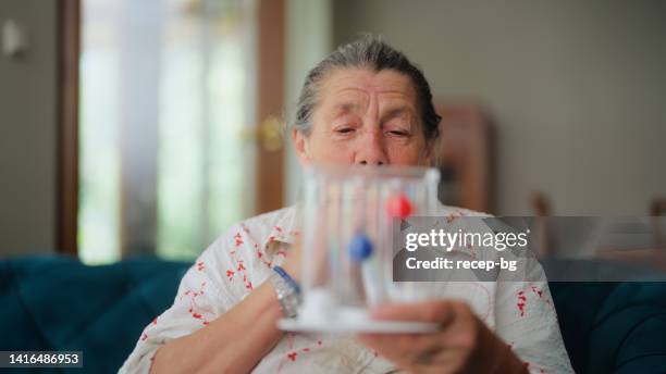 senior woman using spirometer - copd stock pictures, royalty-free photos & images