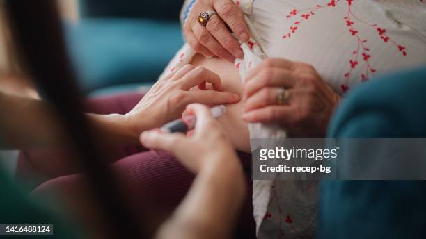 female doctor visiting her elderly patient at her house for medical check - insulin stock pictures, royalty-free photos & images