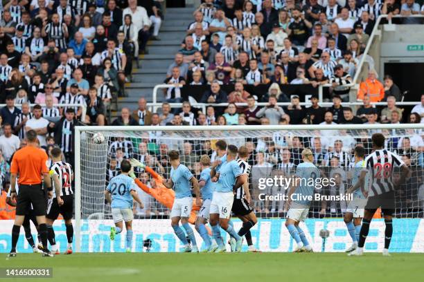 Kieran Trippier of Newcastle United scores their side's third goal from a free kick as Ederson of Manchester City attempts to make a save during the...