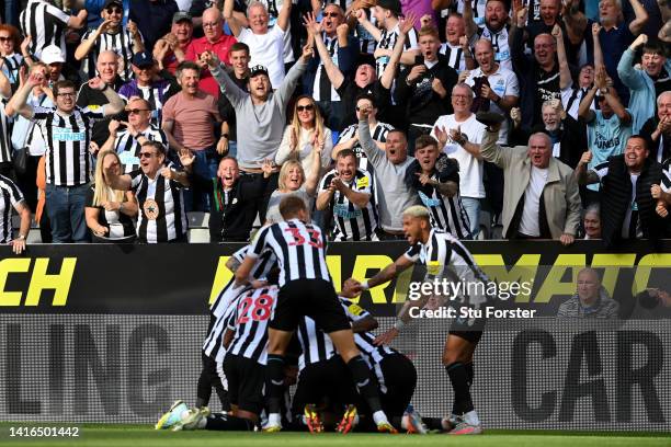 Fans of Newcastle United celebrate as Kieran Trippier of Newcastle United celebrates with teammates after scoring their side's third goal from a free...