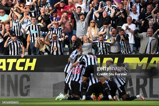 Fans of Newcastle United celebrate as Kieran Trippier of Newcastle United celebrates with teammates after scoring their side's third goal from a free...