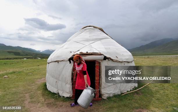 Kyrgyz woman carries on June 17, 2011 milk container in front of her traditional Kyrgyz yurt on the Suu-Samyr plateau 500 meters above the sea level,...