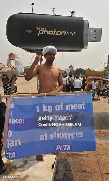 An activist from People for the Ethical Treatment of Animals mimics taking a shower on a roadside in Hyderabad on March 21 to highlight the high...