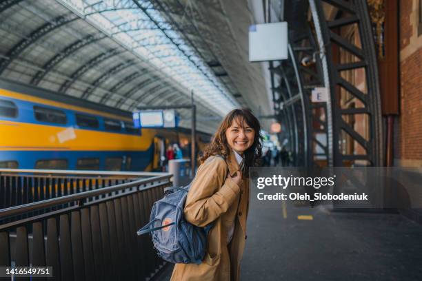 mujer esperando el tren en la estación de tren - trein nederland fotografías e imágenes de stock