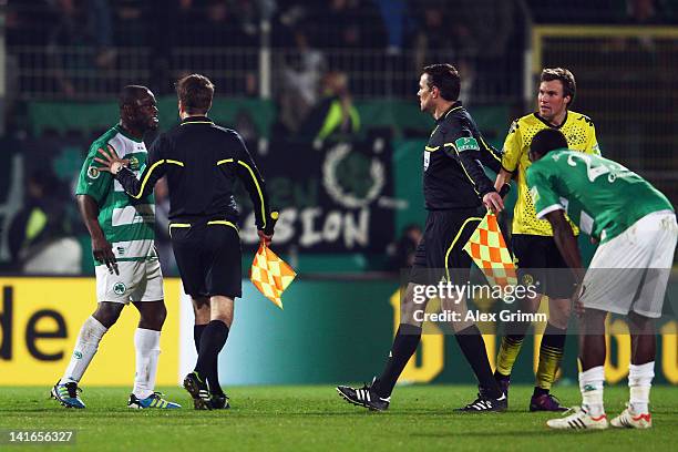 Gerald Asamoah of Greuther Fuerth argues with Kevin Grosskreutz of Dortmund after the DFB Cup semi final match between SpVgg Greuther Fuerth and...
