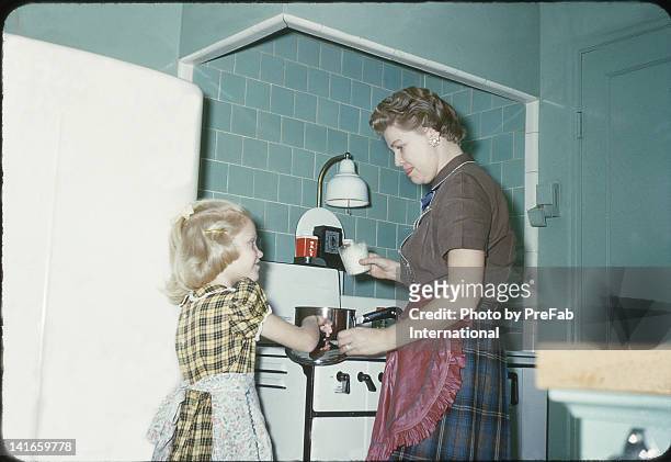 mother and daughter cooking in kitchen - archival stock-fotos und bilder
