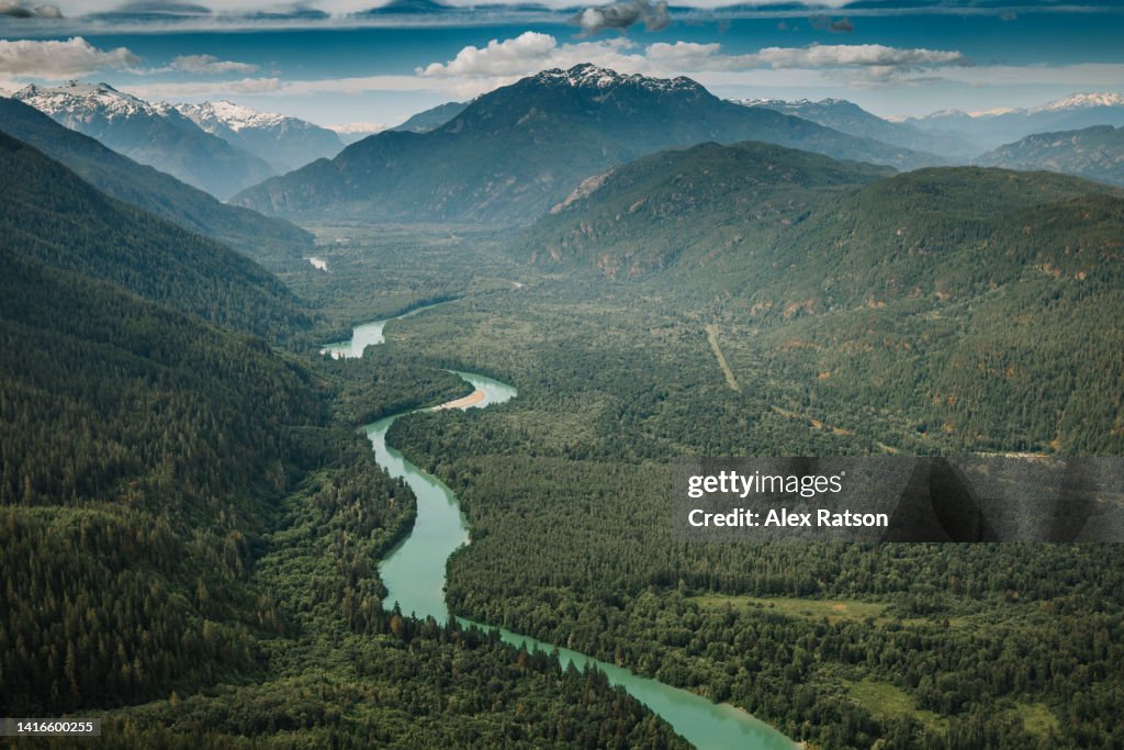 Aerial view of a lush mountain valley with a large river flowing down it