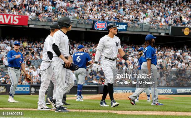 Aaron Judge of the New York Yankees walks to first base after he was hit by a pitch from Alek Manoah of the Toronto Blue Jays during the fifth inning...