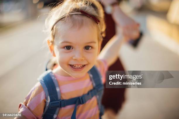 happy daughter being taken to school by her unrecognizable mother - happy toddler stockfoto's en -beelden