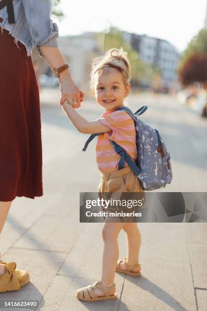 portrait of smiling daughter being taken to school by her unrecognizable mother - school time stock pictures, royalty-free photos & images