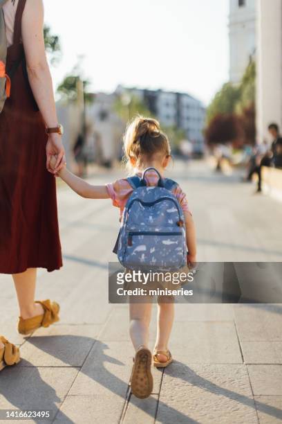 unrecognizable daughter being taken to school by her mother - girl from behind stock pictures, royalty-free photos & images