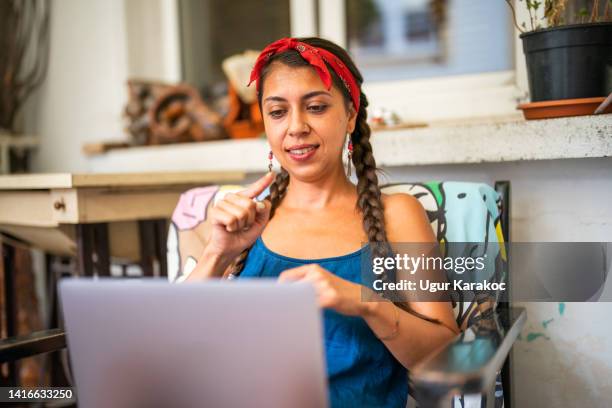 woman having a video call on her laptop - interpreter stock pictures, royalty-free photos & images