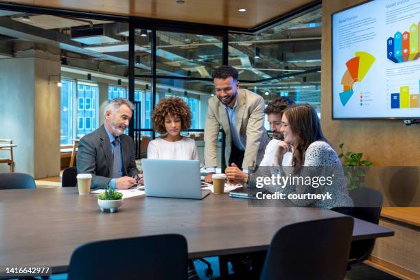 five business people working on a laptop computer in an office conference room. - five people meeting stock pictures, royalty-free photos & images