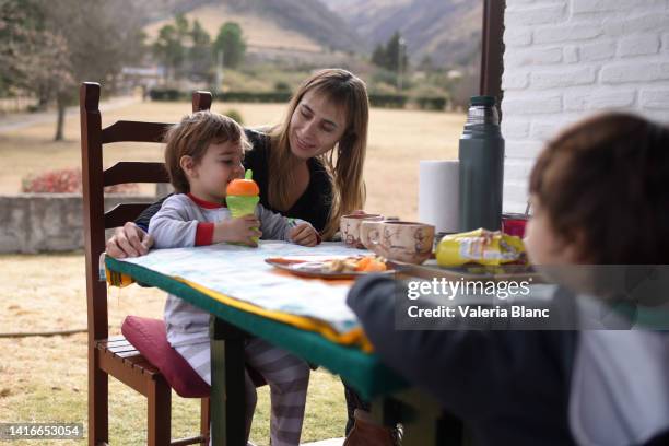 woman having breakfast with her children - table fond blanc stock pictures, royalty-free photos & images