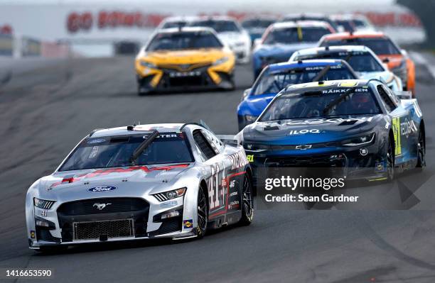 Cole Custer, driver of the HaasTooling.com Ford, and Kimi Raikkonen, driver of the Recogni Chevrolet, race during the NASCAR Cup Series Go Bowling at...