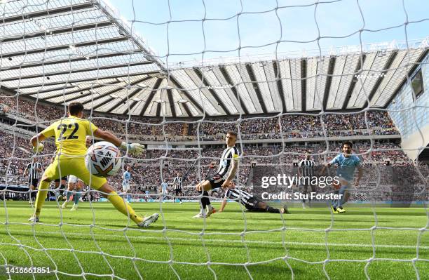 Ilkay Gundogan of Manchester City shoots past Newcastle goalkeeper Nick Pope for the first City goal during the Premier League match between...