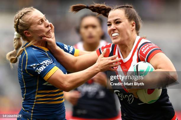 Isabelle Kelly of the Roosters fends Abbi Church of the Eels during the round one NRLW match between the Parramatta Eels and the Sydney Roosters at...