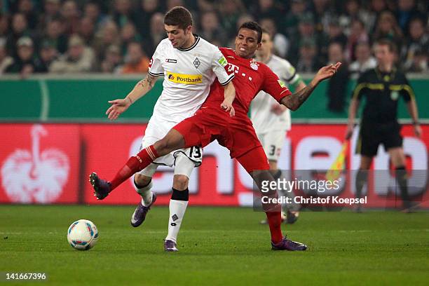 Luiz Gustavo of Bayern challenges Roman Neustaedter of Moenchengladbach during the DFB Cup semi final match between Borussia Moenchengladbach and FC...
