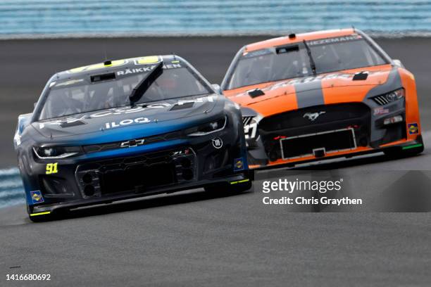 Kimi Raikkonen, driver of the Recogni Chevrolet, and Loris Hezemans, driver of the Hezeberg Systems Ford, race during the NASCAR Cup Series Go...