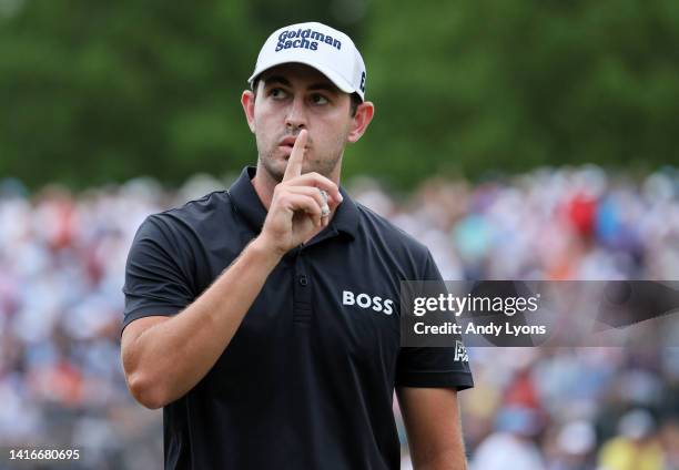 Patrick Cantlay of the United States quiets the crowd before his playing partner Xander Schauffele of the United States putts on the 18th green...