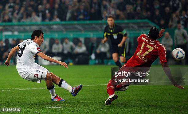 Juan Arango of Moenchengladbach shoots on goal next to Jerome Boateng of Muenchen during the DFB Cup semi final match between Borussia...