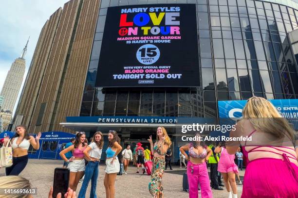 Fans wearing themed outfits take photos outside Madison Square Garden before the Harry Styles Love On Tour 2022 concert on August 21, 2022 in New...