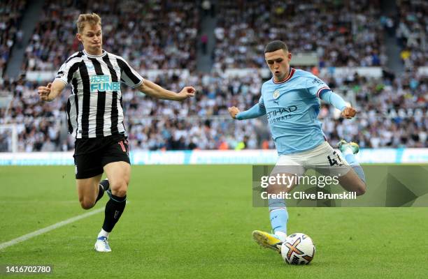 Phil Foden of Manchester City attempts to cross the ball past Emil Krafth of Newcastle United during the Premier League match between Newcastle...