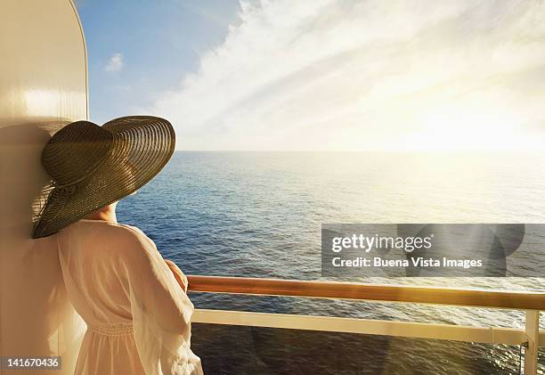 woman looking out to sea on a cruise ship - bateau croisiere photos et images de collection