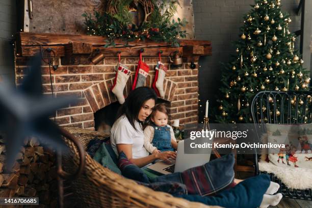 online christmas party. happy black family in red santa claus hat using laptop pc making video call celebrating xmas distantly sitting on floor at home, holding showing gifts. new year holiday concept - weihnachten laptop stock-fotos und bilder