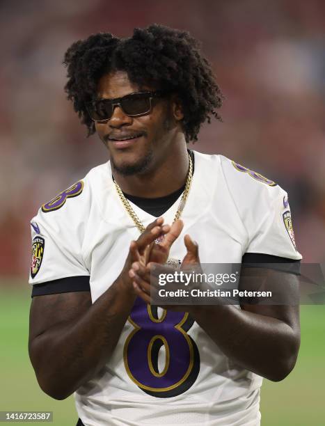 Quarterback Lamar Jackson of the Baltimore Ravens stands on the sidelines during the first half of the NFL preseason game at State Farm Stadium on...