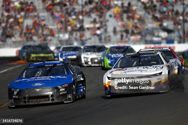 Chris Buescher, driver of the Fastenal Ford, and AJ Allmendinger, driver of the Action Industries Chevrolet, race during the NASCAR Cup Series Go...