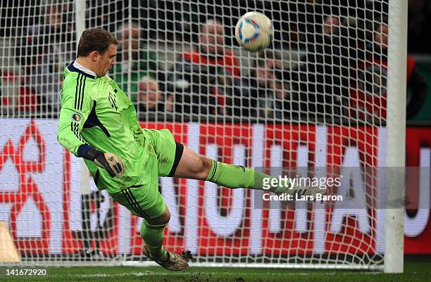 Goalkeeper Manuel Neuer of Muenchen saves the last penalty of Havard Nordtveit of Moenchengladbach during the DFB Cup semi final match between...