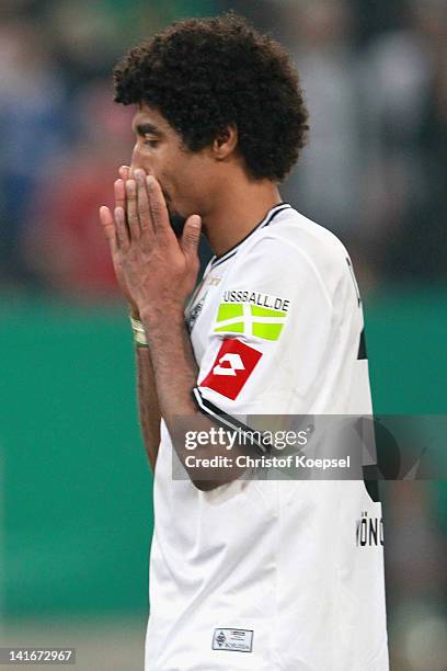 Dante of Moenchengladbach looks dejected after missing a penalty durign the penalty shoot-out during the DFB Cup semi final match between Borussia...