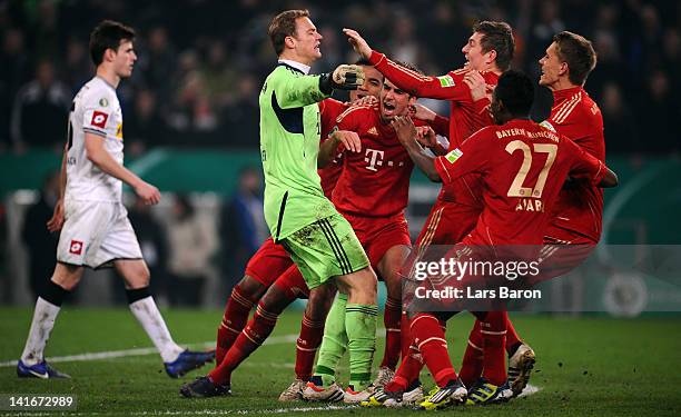 Goalkeeper Manuel Neuer of Muenchen celebrates with team mates after saving the last penalty of Halvard Nordtveit of Moenchengladbach during the DFB...