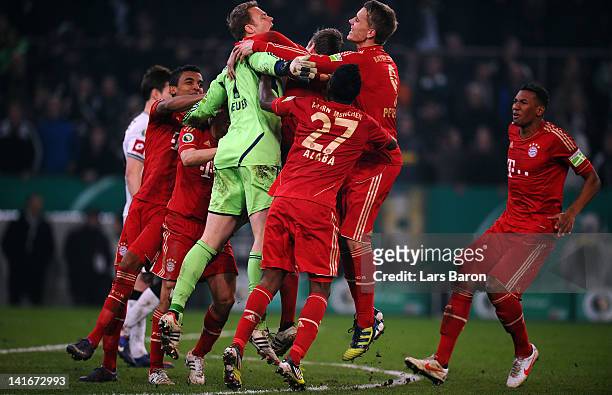 Goalkeeper Manuel Neuer of Muenchen celebrates with team mates after saving the last penalty of Halvard Nordtveit of Moenchengladbach during the DFB...