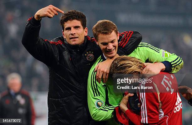 Goalkeeper Manuel Neuer of Muenchen celebrates with team mates Mario Gomez and Anatoliy Tymoshchuk after winning the DFB Cup semi final match between...