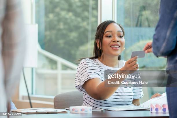 volontario adulto medio che controlla la carta d'identità degli elettori. - iscrizione nelle liste elettorali foto e immagini stock