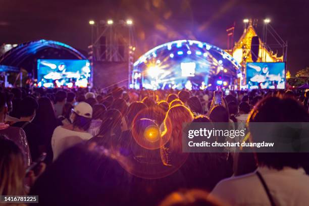 people at music festival with illuminated lights at night background - festival stockfoto's en -beelden