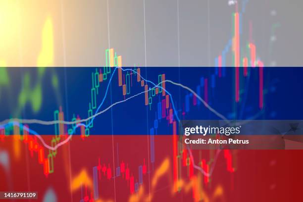 russian flag on the background of stock charts. concept of economic sanctions in russia - russische kultur stock-fotos und bilder